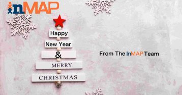Wooden christmas tree with text Merry Christmas and snow flakes on light gray stone background