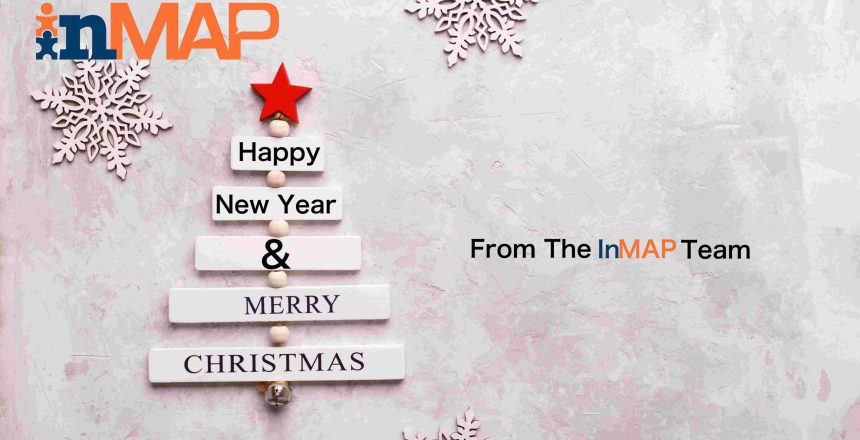 Wooden christmas tree with text Merry Christmas and snow flakes on light gray stone background